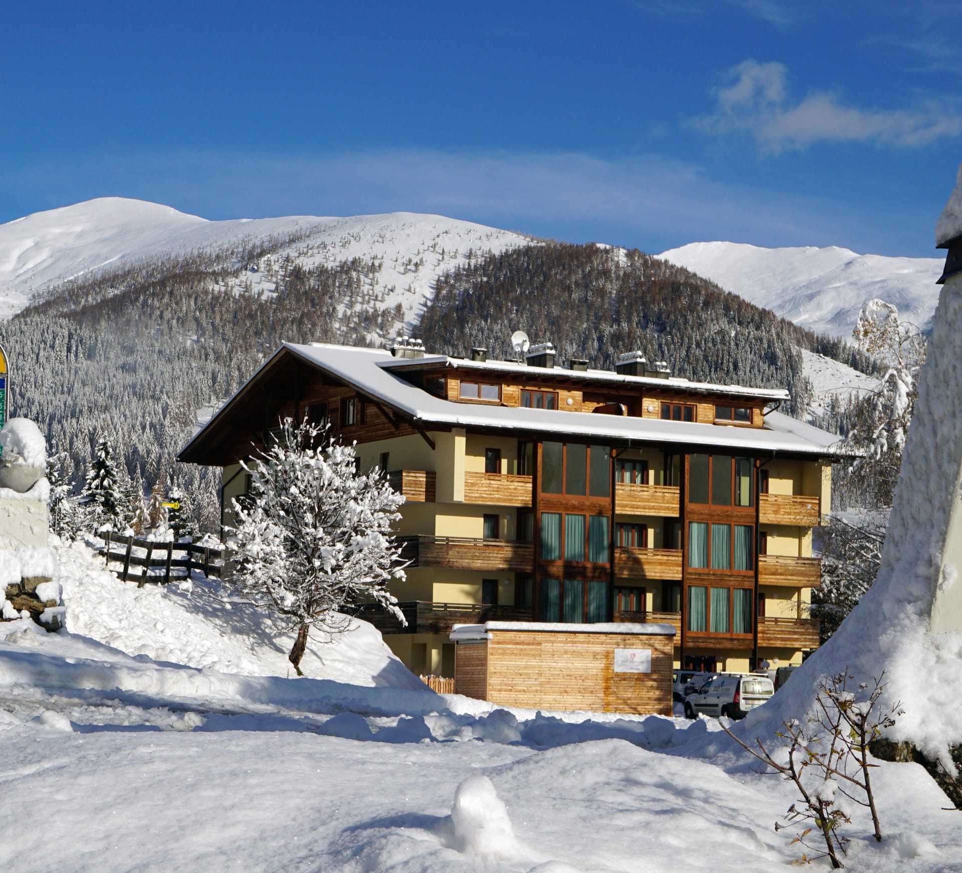 The building from outside in winter, snow-covered, mountains behind.