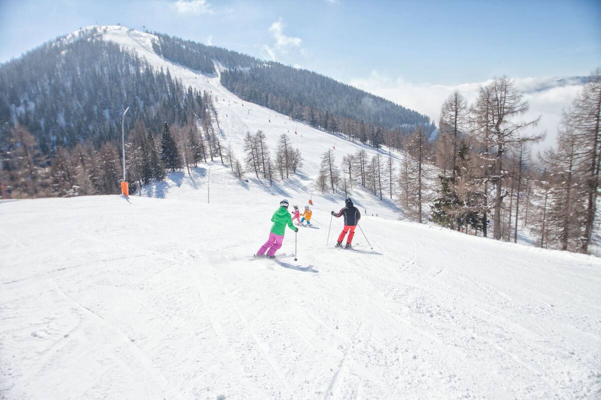 A family skiing down a slope in Bad Kleinkirchheim.